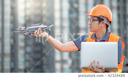 Engineer using drone and laptop for site survey 42328489