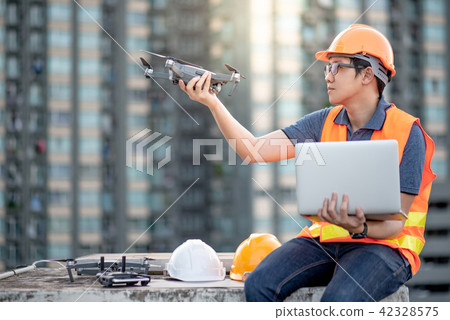 Engineer using drone and laptop for site survey 42328575