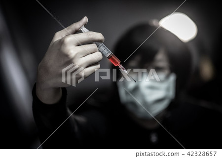 Young man using syringe for red drug injection Young man using syringe for red drug injection 42328657