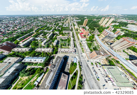 Aerial city view with crossroads and roads, houses, buildings, parks and parking lots. Sunny summer 42329085