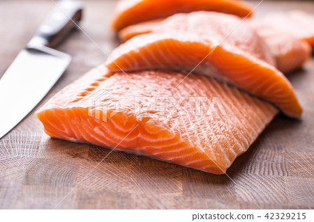 Close-up raw salmon fillets on wooden table 42329215