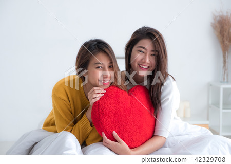 Asia lesbian lgbt couple holding red heart pillow  42329708