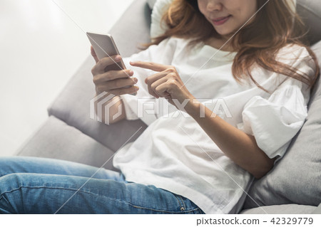 Young woman using smartphone at cozy home Young woman using smartphone at cozy home 42329779