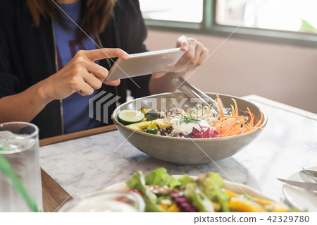 Young woman taking photo of food Young woman taking photo of food 42329780