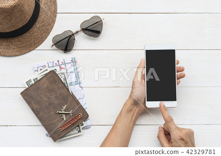 Traveler holding smart phone with passport Traveler holding smart phone with passport 42329781