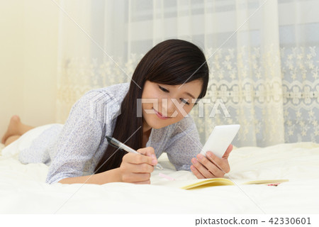 A woman relaxing in the bedroom A woman relaxing in the bedroom 42330601