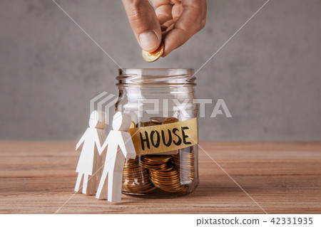 Glass jar with coins and house and family 42331935