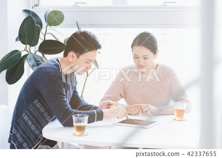 A couple who consults with a tablet PC and enjoys online shopping 42337655