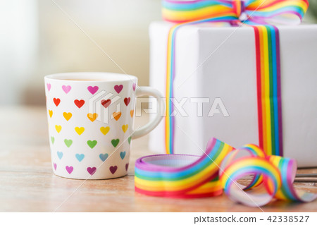 close up of cup, gift box and gay awareness ribbon close up of cup, gift box and gay awareness ribbon 42338527