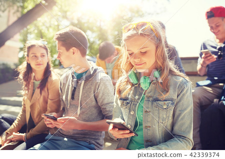 teenage friends with smartphone and headphones teenage friends with smartphone and headphones 42339374
