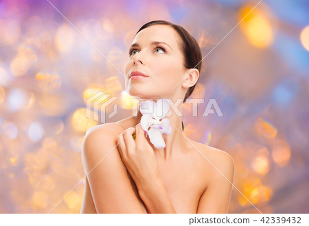woman with orchid flower over green background 42339432