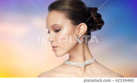 close up of beautiful woman face with earring 42339460