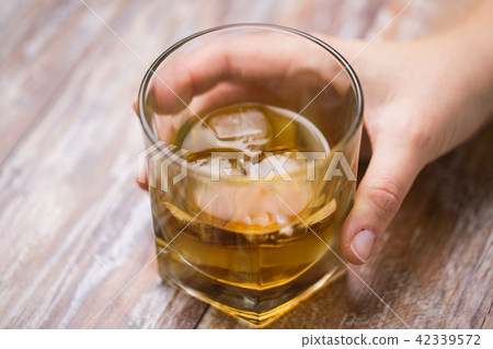male hand with glass of alcohol on table 42339572