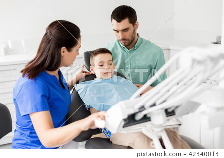 father and son visiting dentist at dental clinic father and son visiting dentist at dental clinic 42340013