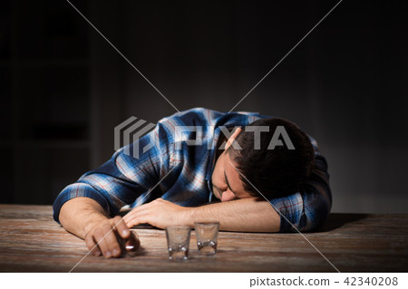 drunk man with empty glasses on table at night drunk man with empty glasses on table at night 42340208