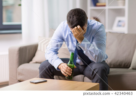 male alcoholic drinking beer at home 42340463