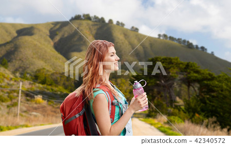 smiling woman with backpack on big sur hills 42340572