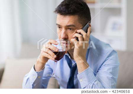 drunk man with alcohol calling on smartphone 42340658