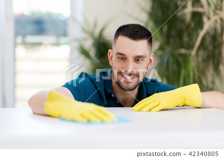 smiling man cleaning table with cloth at home smiling man cleaning table with cloth at home 42340805