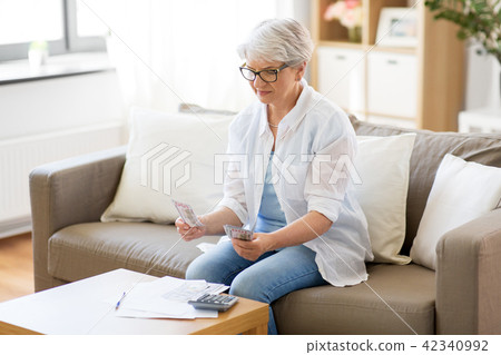senior woman counting money at home senior woman counting money at home 42340992