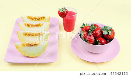Fresh strawberries in bowl and melone on pastel yellow background. 42342113
