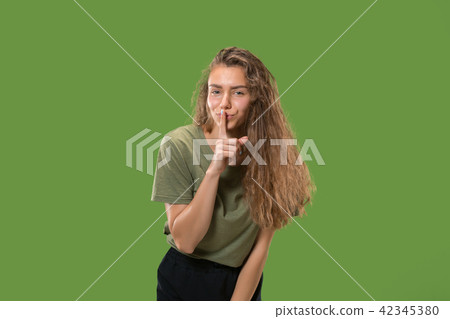 The young woman whispering a secret behind her hand The young woman whispering a secret behind her hand 42345380