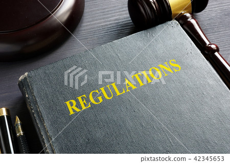 Regulations book and gavel in a court. Law. Regulations book and gavel in a court. Law. 42345653