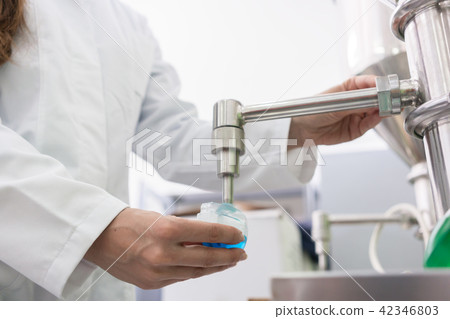 Technician filling container with liquid for laboratory tests Technician filling container with liquid for laboratory tests 42346803