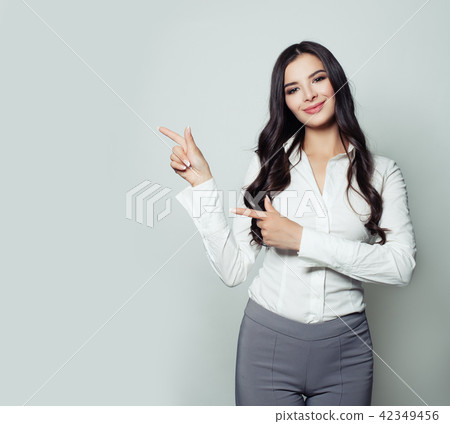 Smiling businesswoman pointing her finger to empty Smiling businesswoman pointing her finger to empty 42349456