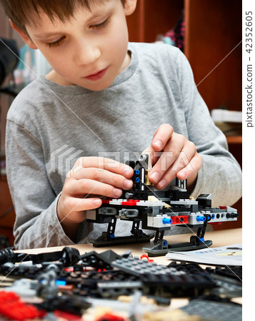 Little boy plays and collects children plastic construction toys Little boy plays and collects children plastic construction toys 42352605
