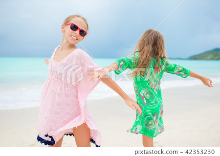 Happy girls having fun and enjoying vacation on tropical beach with white sand and turquoise ocean 42353230