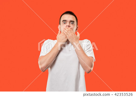 The young man whispering a secret behind her hand over orange background The young man whispering a secret behind her hand over orange background 42353526