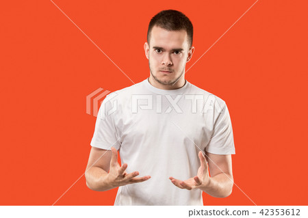 The young emotional angry man on orange studio background The young emotional angry man on orange studio background 42353612