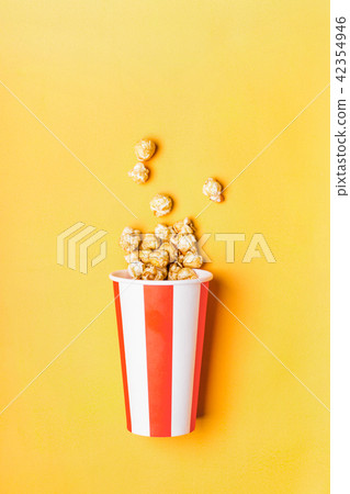 Sweet caramel popcorn in paper striped cup 42354946
