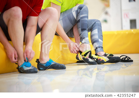 Photo of man and woman wearing athletic shoes in gym 42355247