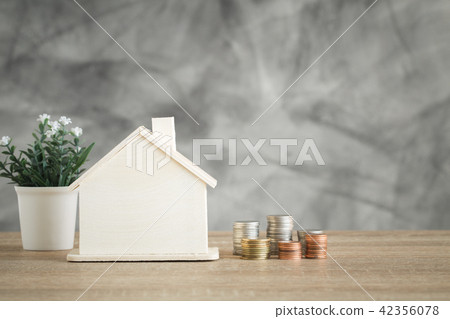 Wooden house model and coin money on wood table Wooden house model and coin money on wood table 42356078