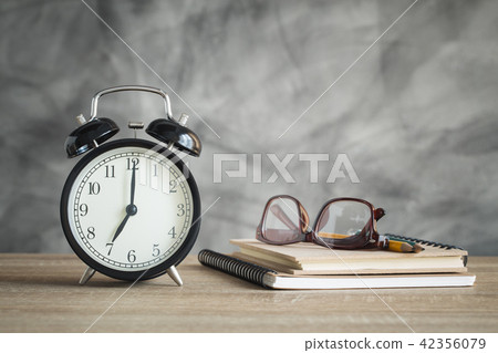 Alarm clock on wood table with school supplies Alarm clock on wood table with school supplies 42356079