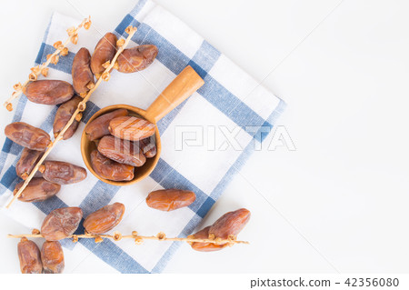Dates fruit in wooden ladle on white background Dates fruit in wooden ladle on white background 42356080