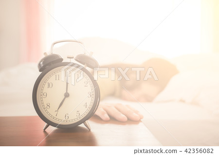 Alarm clock with woman sleeping on bed Alarm clock with woman sleeping on bed 42356082