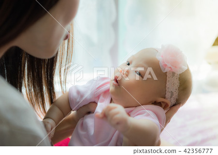 Mother and little baby laughing, playing together Mother and little baby laughing, playing together 42356777