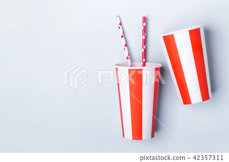 Two Empty striped paper cup on a blue background Two Empty striped paper cup on a blue background 42357311