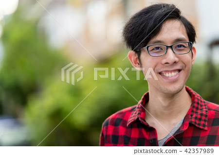 Young happy Asian man outdoors 42357989