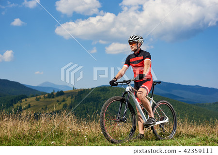 Professional cyclist in sportswear and helmet cycling mountain bicycle 42359111