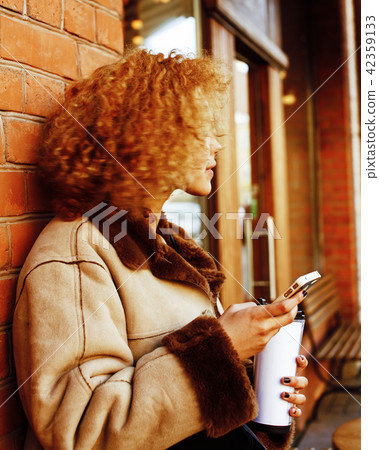 young pretty african american women drinking coffee outside in c 42359133