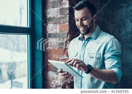 Bearded Man Call Using Tablet PC near Window. Bearded Man Call Using Tablet PC near Window. 42360595