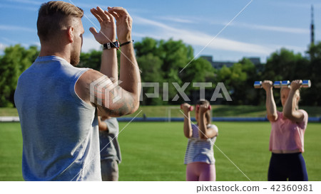 Man training family with kids on field Man training family with kids on field 42360981