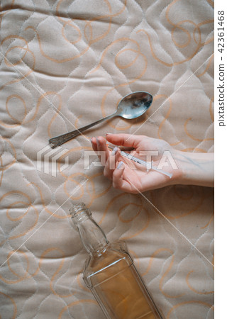 Female junkie hand with syringe, bottle and spoon Female junkie hand with syringe, bottle and spoon 42361468
