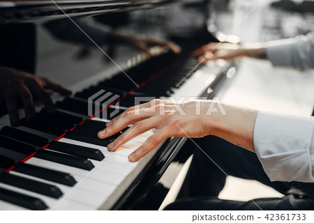 Male pianist hands on grand piano keyboard