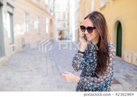 Woman talk by her smartphone in city. Young attractive tourist outdoors in italian city 42362964
