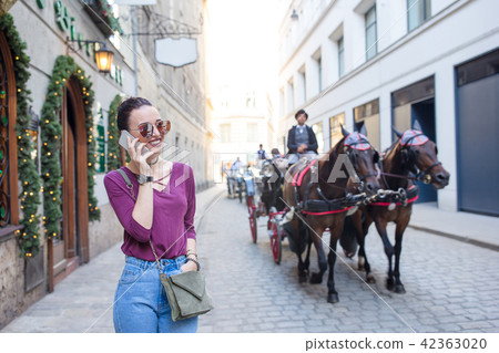 Woman talk by her smartphone in city. Young attractive tourist outdoors in italian city 42363020